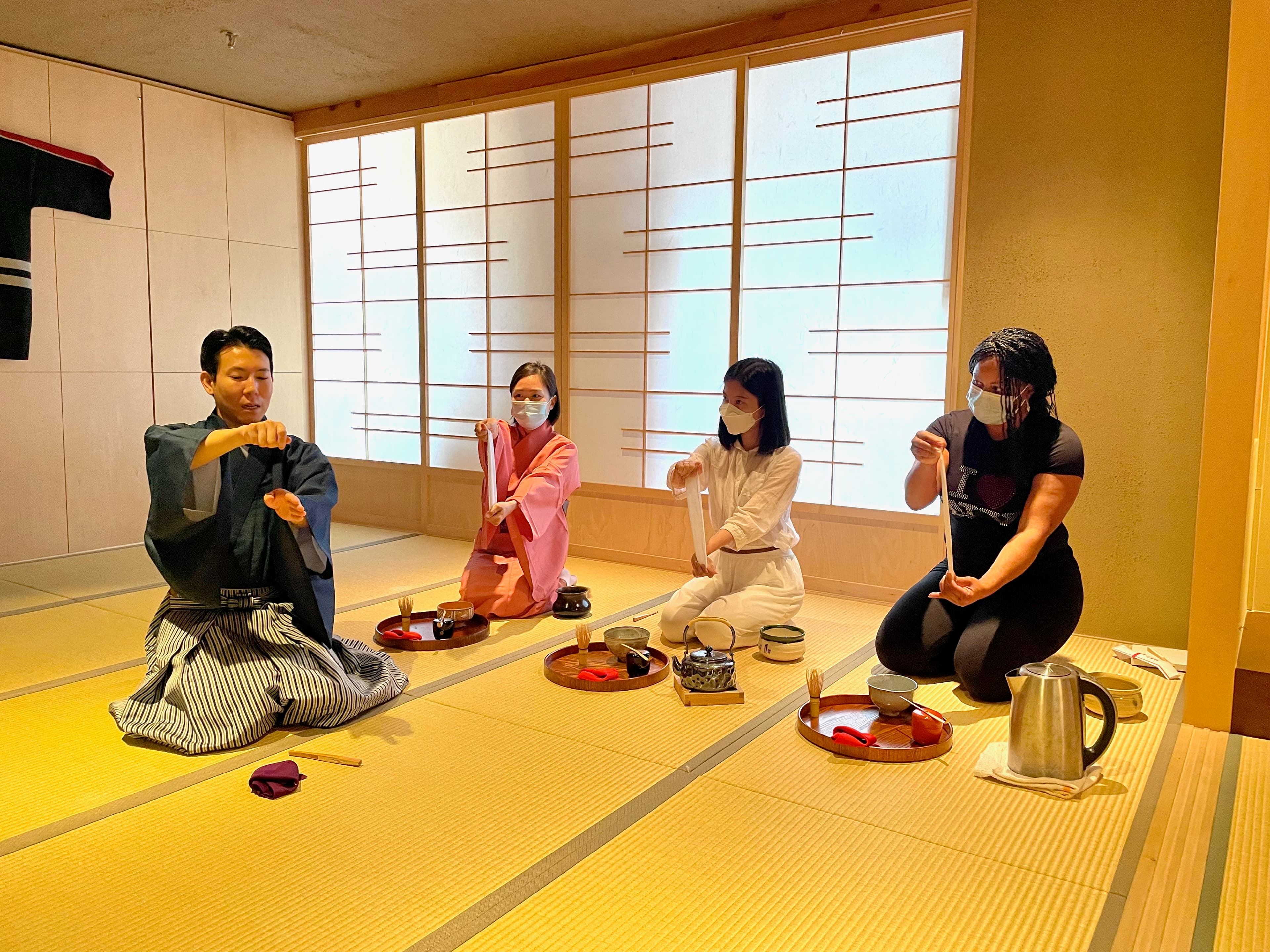 Students working through bon-temae on lacquer trays, with Nagano demonstrating