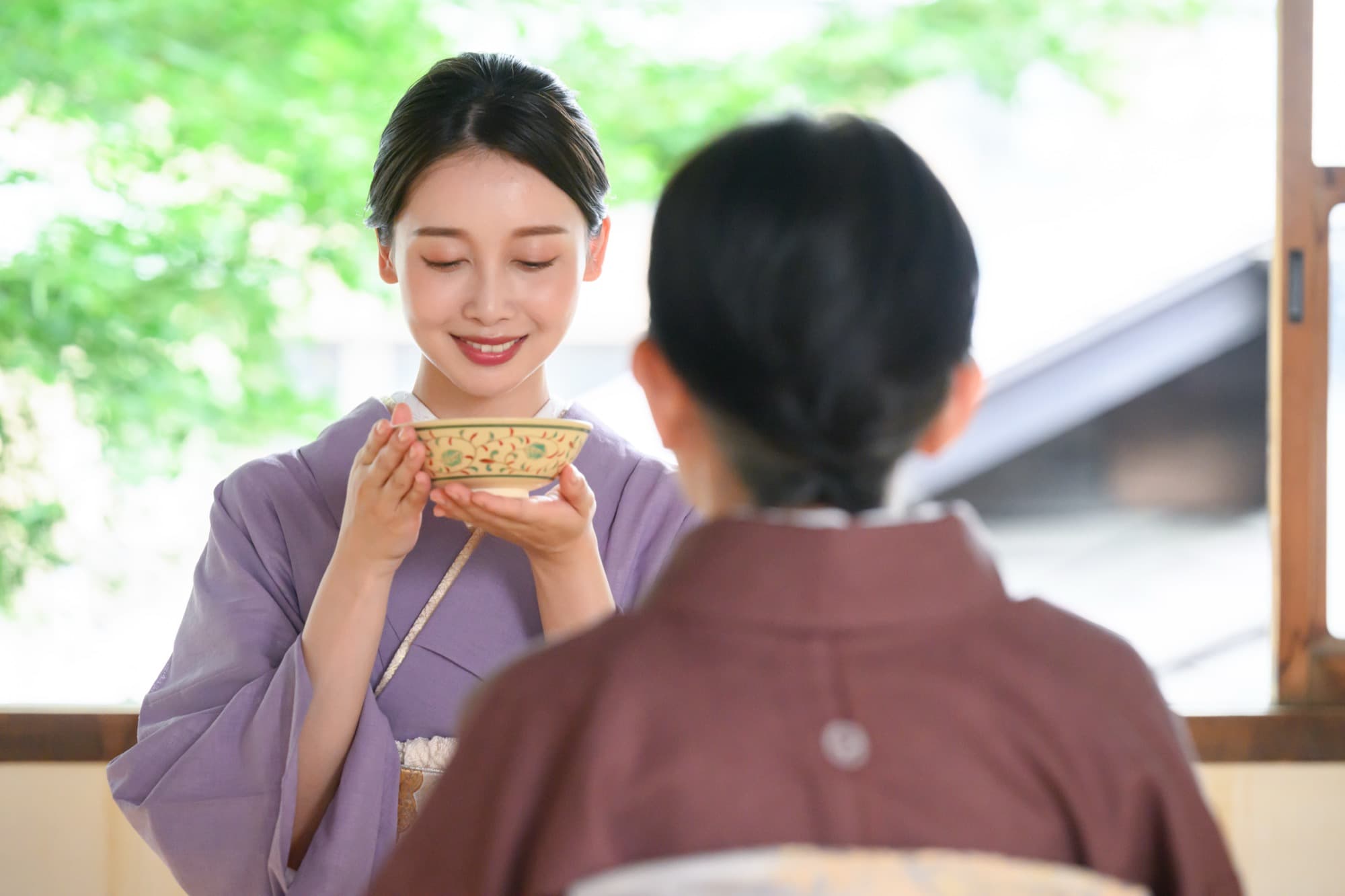 A guest raising the bowl in both hands before drinking