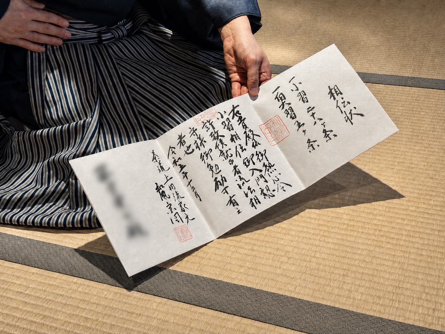A kyōjō certificate from Ueda Sōko Ryū, held open on the tatami