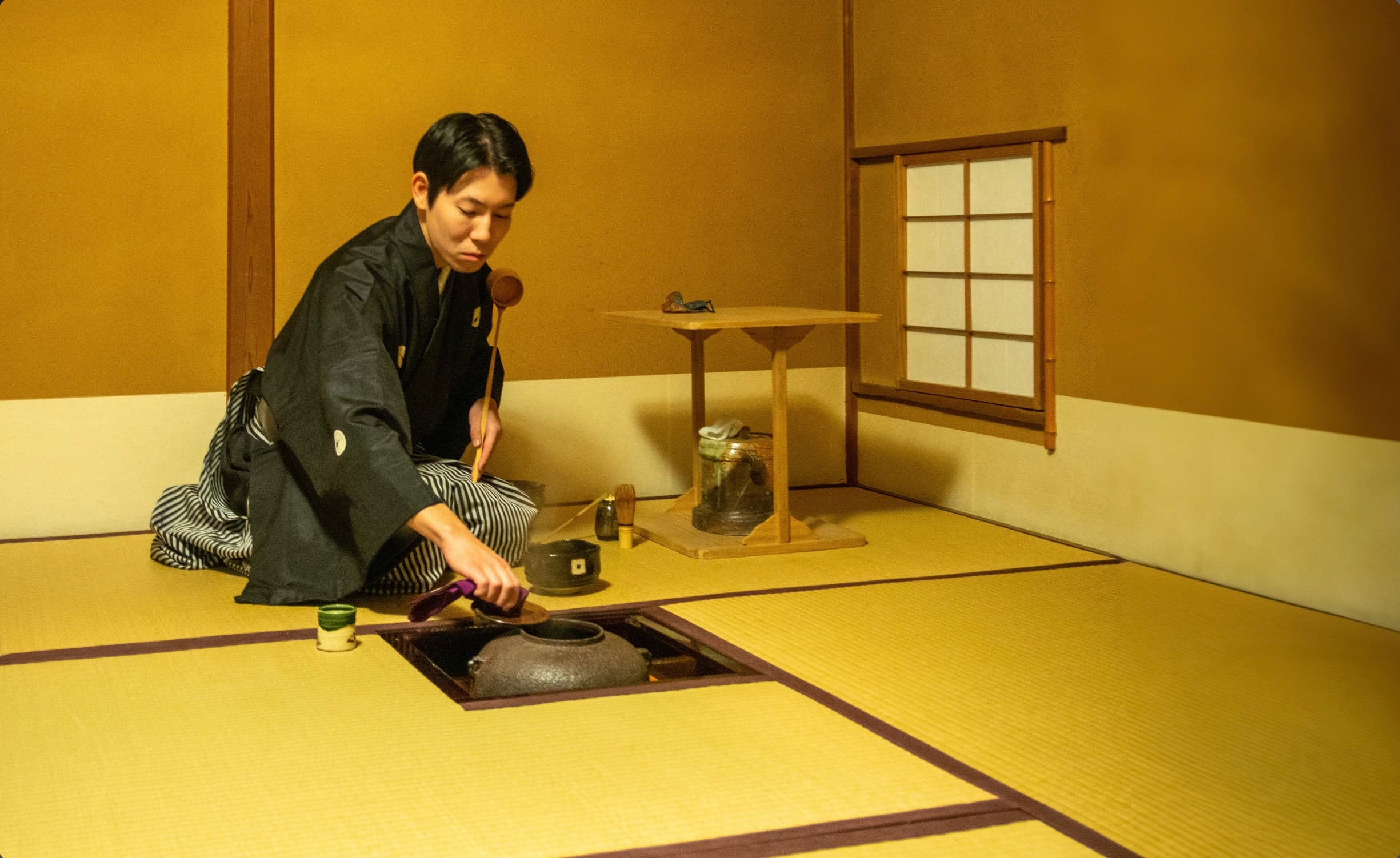 Nagano preparing tea at the sunken hearth in a tea room